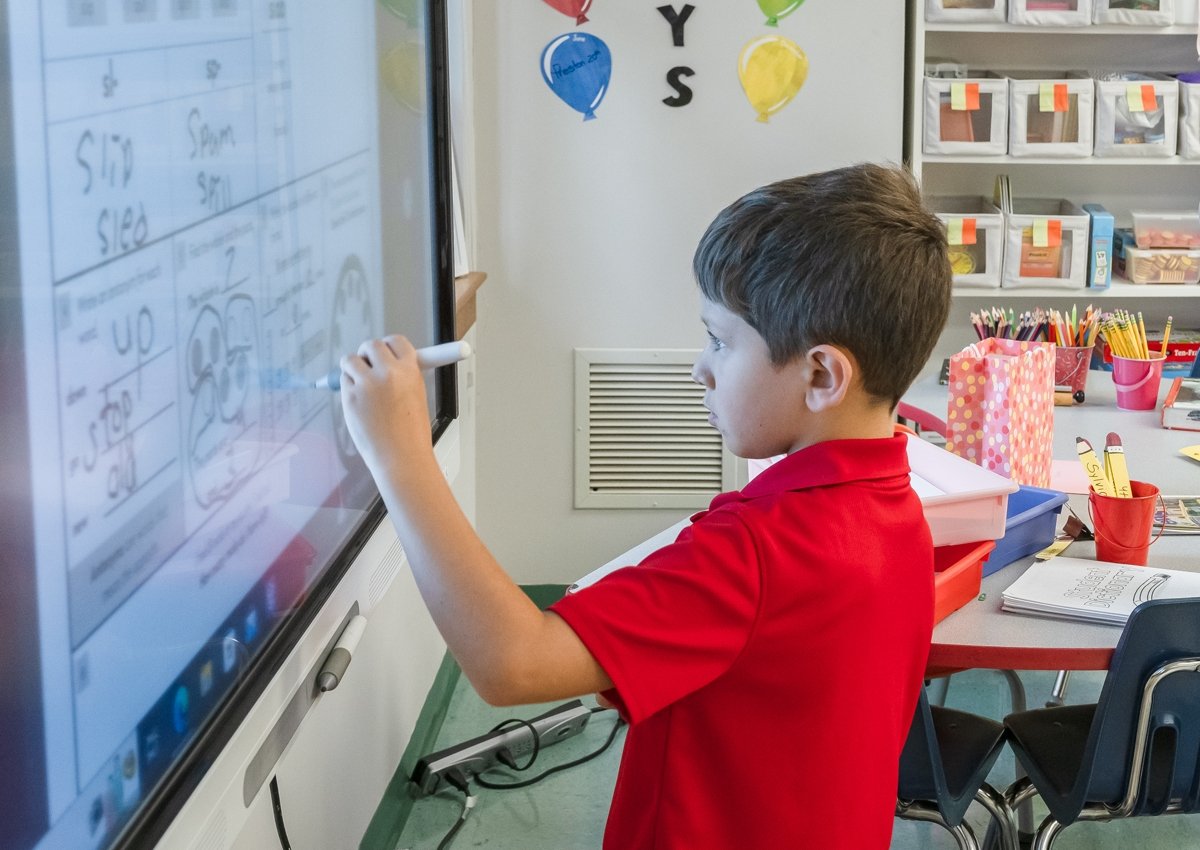 lower school student writing on the whiteboard