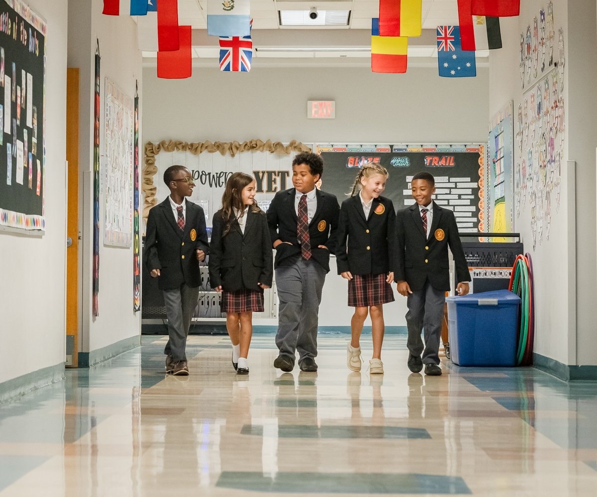 lower school students in school uniform walking in the hallway