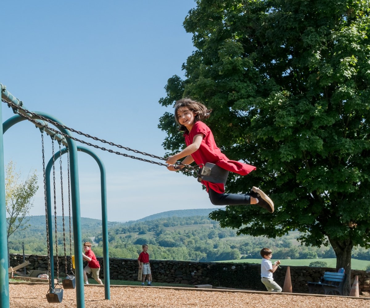 student on a swing on the playground