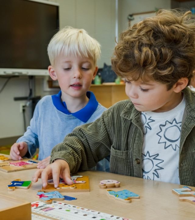 two lower school students putting puzzles together