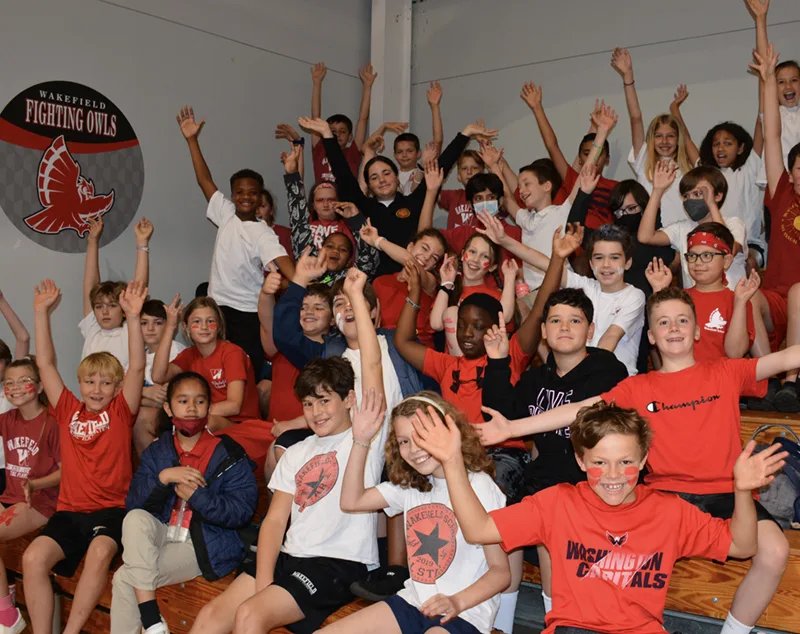 students in gymnasium bleachers dressed for field day
